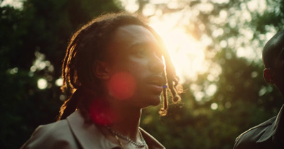 a man with dreadlocks standing next to another man