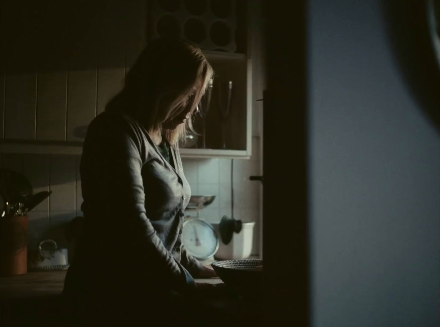 a woman standing in a kitchen with a laptop