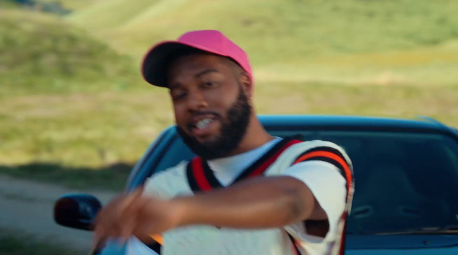 a man in a pink hat pointing at something