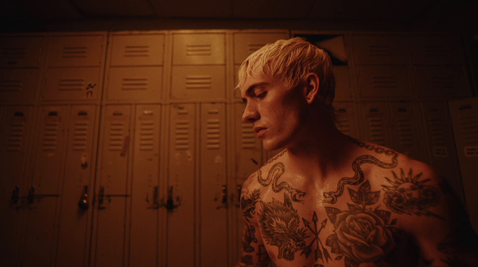 a man with tattoos standing in front of lockers