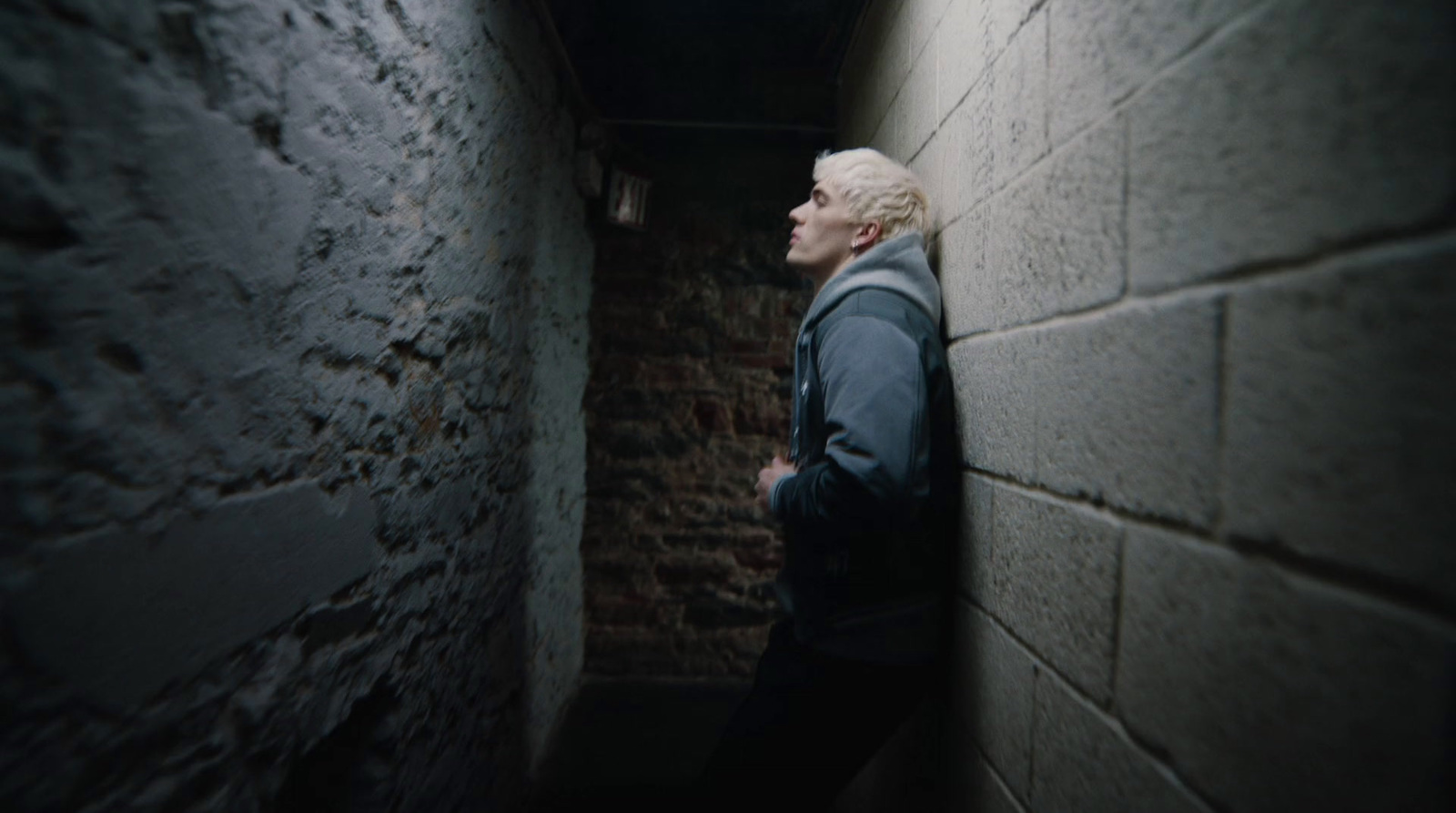 a man standing in a narrow alley way