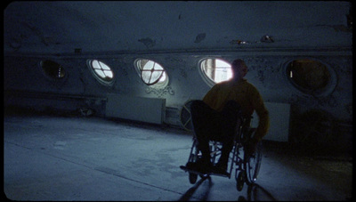 a man in a wheel chair in a room with round windows