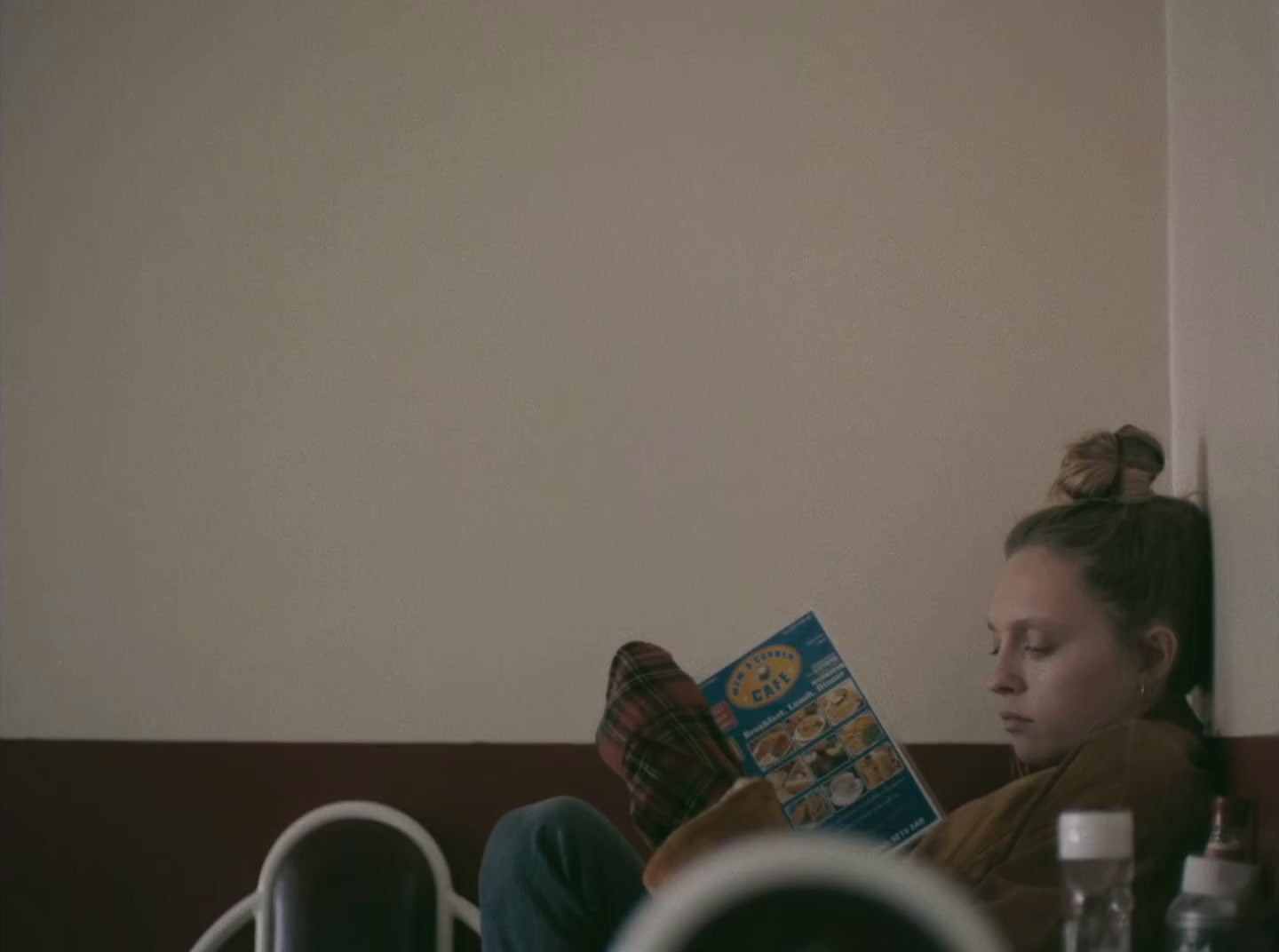 a woman sitting on a couch reading a book