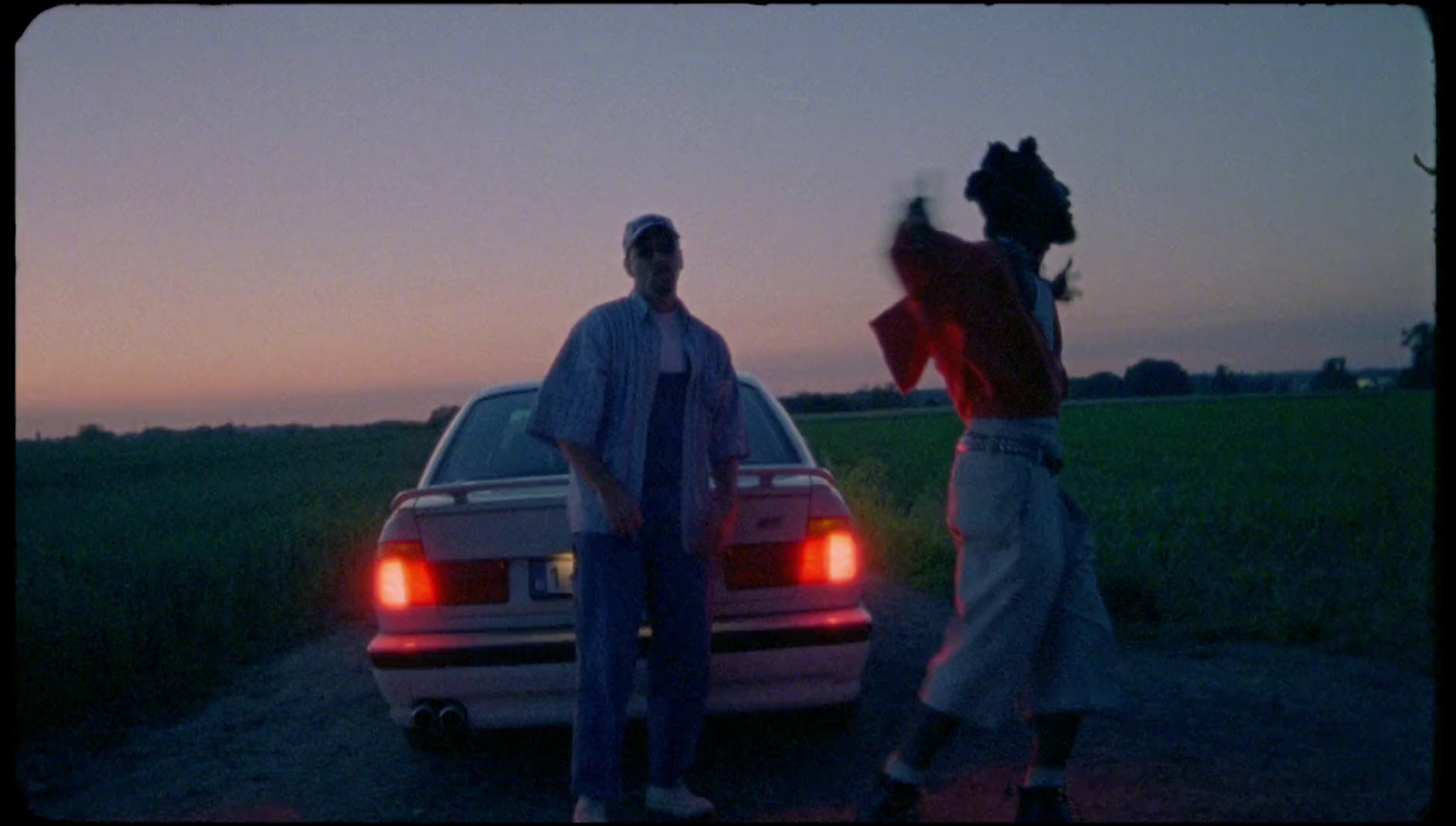 a couple of men standing next to a car