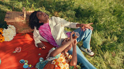 a man and a woman laying on a blanket in the grass