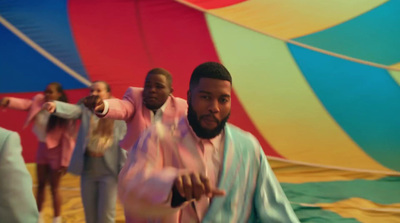 a group of men standing in front of a colorful hot air balloon