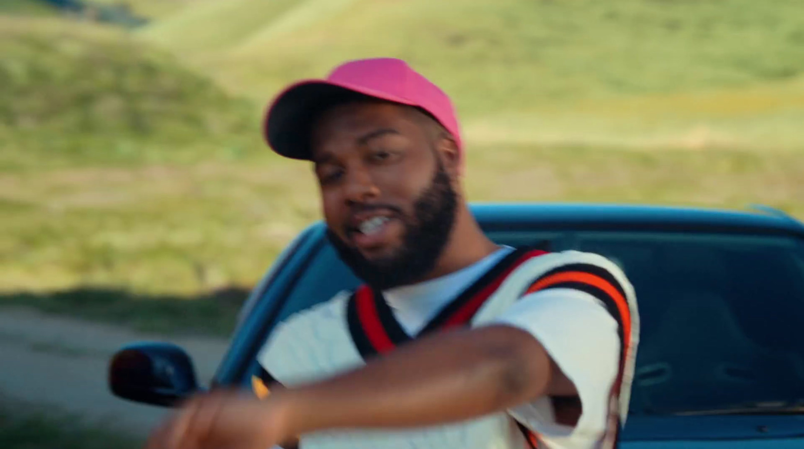 a man wearing a pink hat and holding a baseball bat