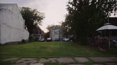 a grassy yard with a white building in the background