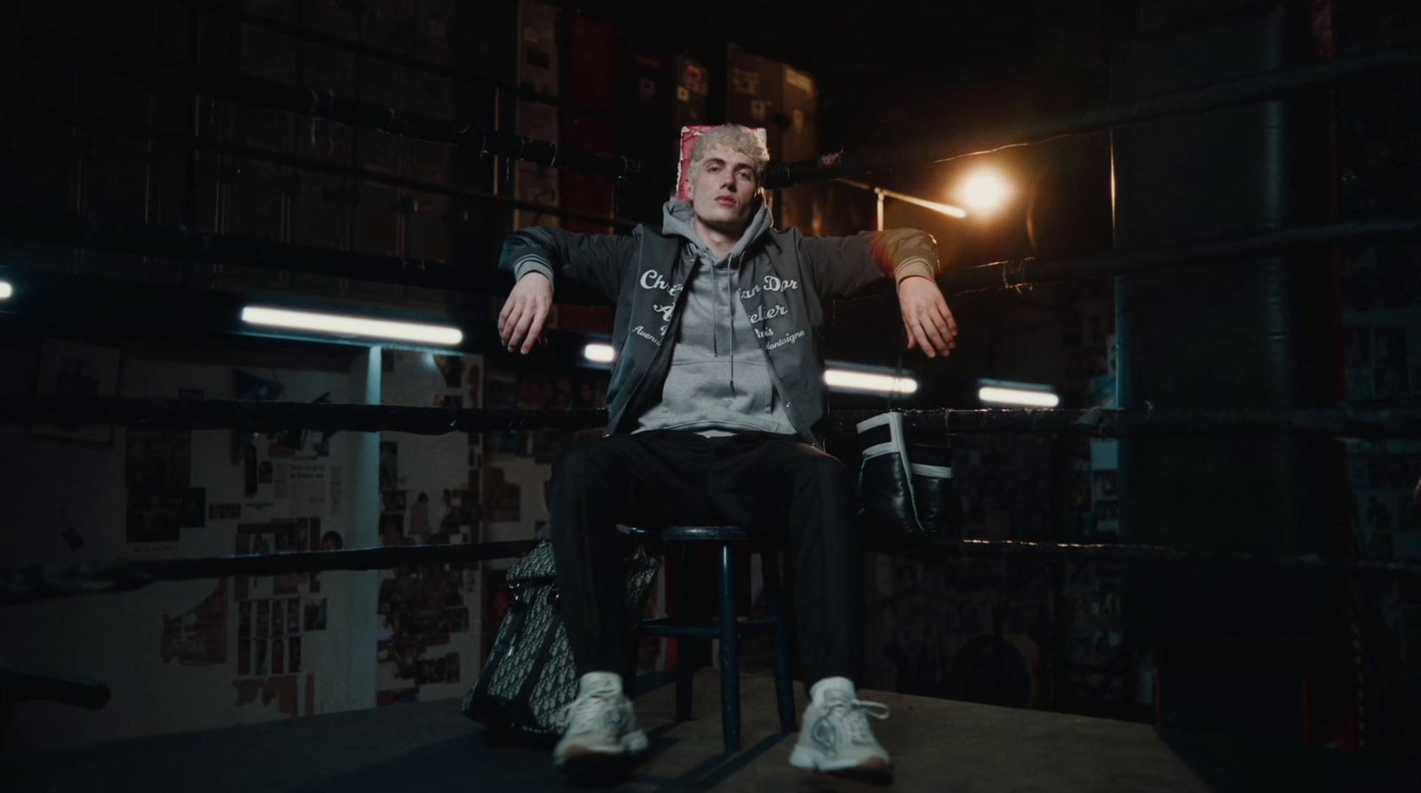 a man sitting on a stool in a dark room