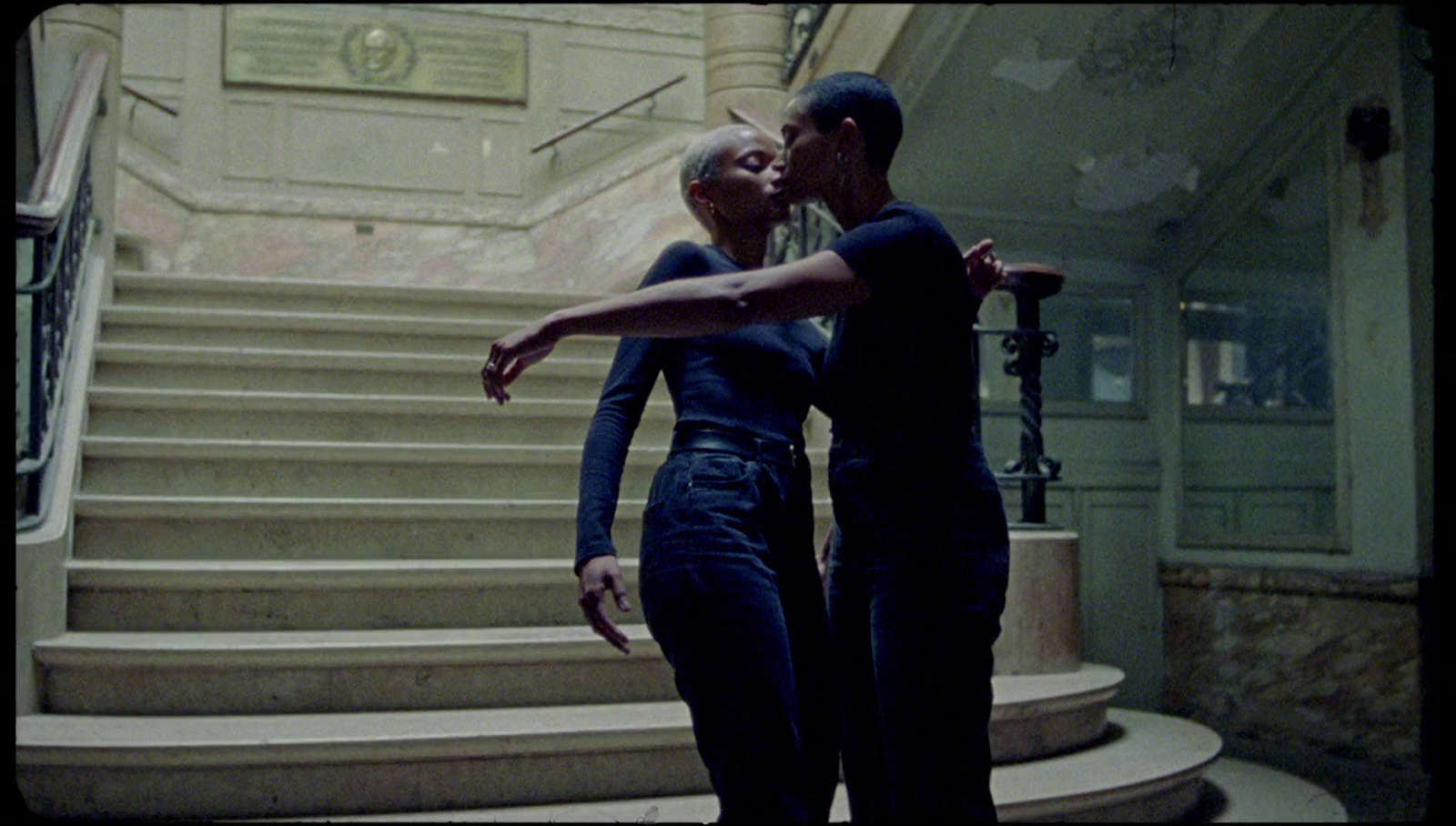 a man and a woman standing in front of a set of stairs