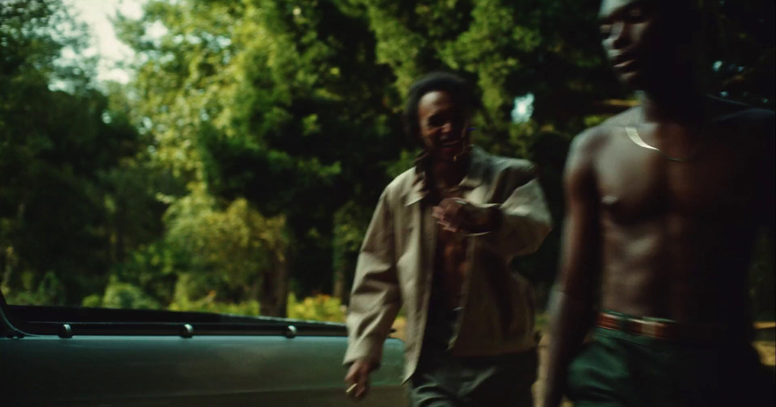 a couple of men standing next to a car