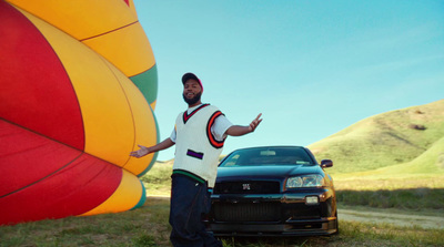 a man standing next to a car near a hot air balloon