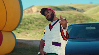 a man standing next to a car giving a thumbs up