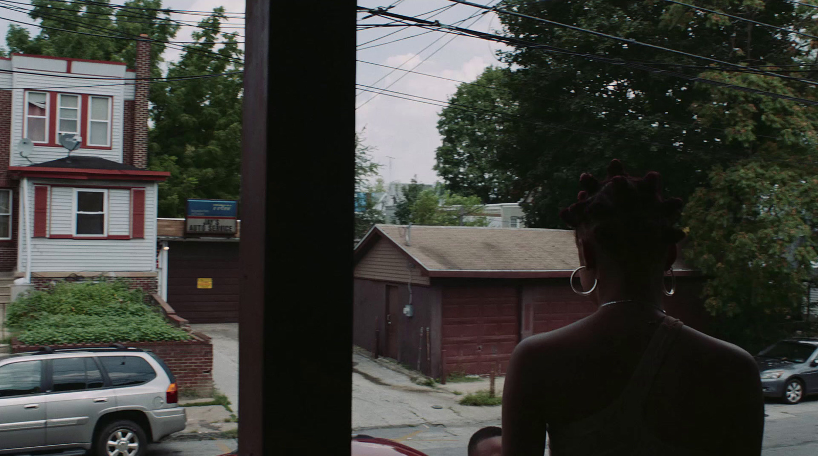 a woman standing in front of a window next to a car