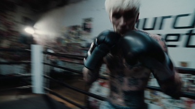 a man with white hair and tattoos wearing boxing gloves