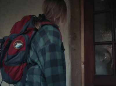 a person with a backpack standing in front of a door