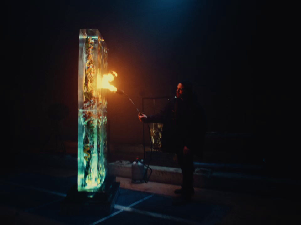 a man standing next to a tall glass sculpture