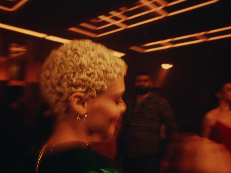 a woman with curly hair standing in a dark room