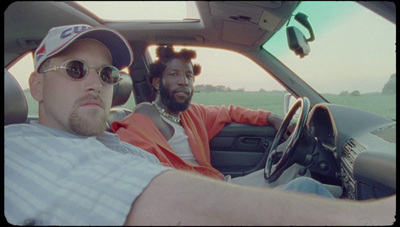 two men sitting in the driver's seat of a car