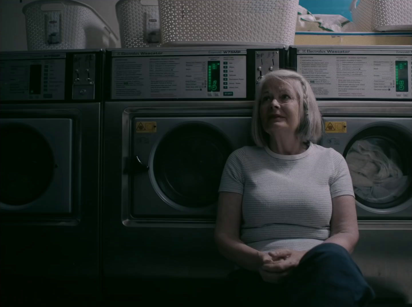 a woman sitting in front of a stack of washers