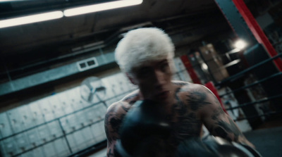 a man with white hair and tattoos in a gym