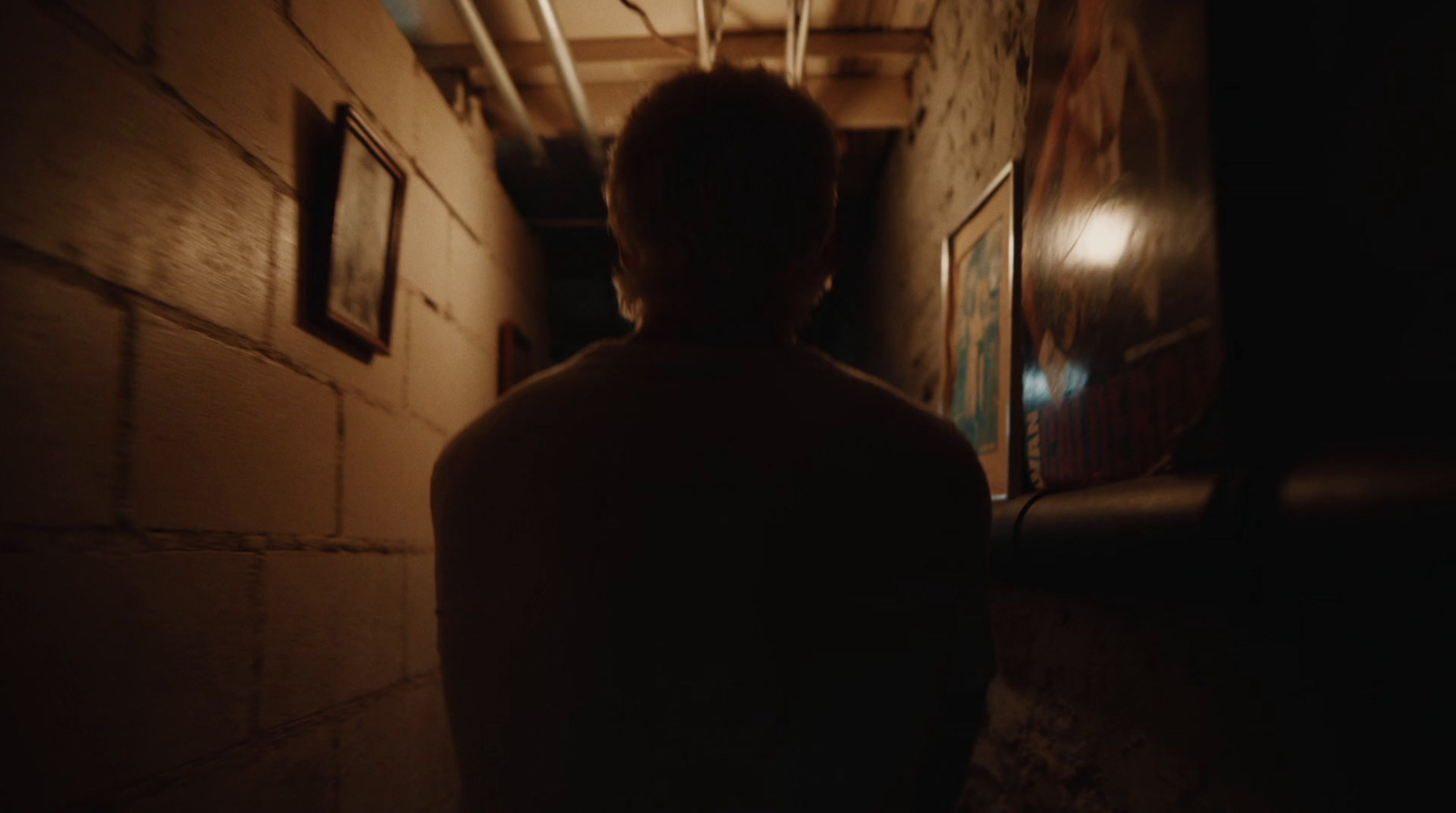 a man is walking down a dark hallway