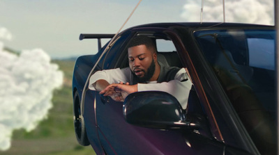 a man sitting in a car looking at his cell phone