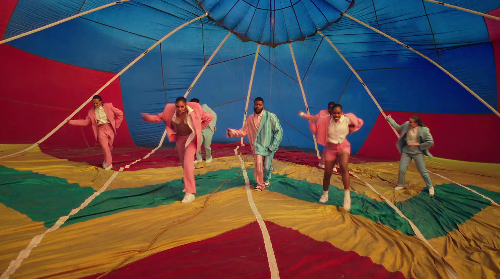 a group of men standing on top of a parachute