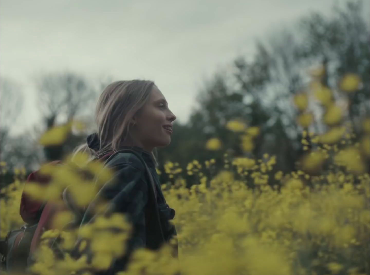 a woman standing in a field of yellow flowers