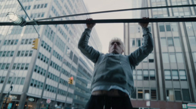 a man holding a pole above his head in a city