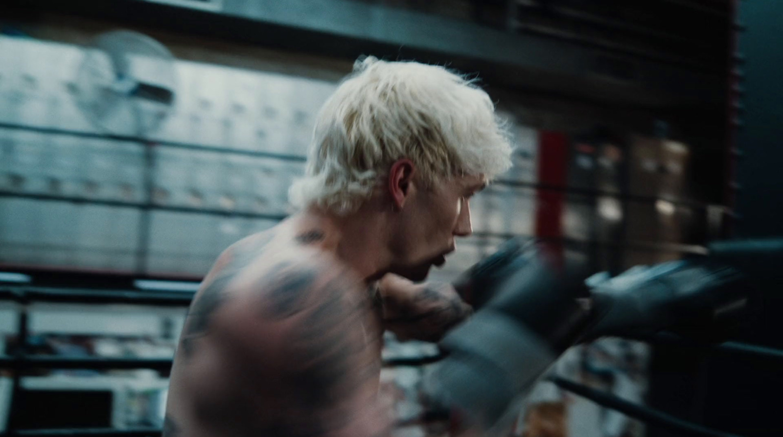 a man with white hair is boxing in a ring