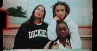 three girls are posing for a picture on a television screen