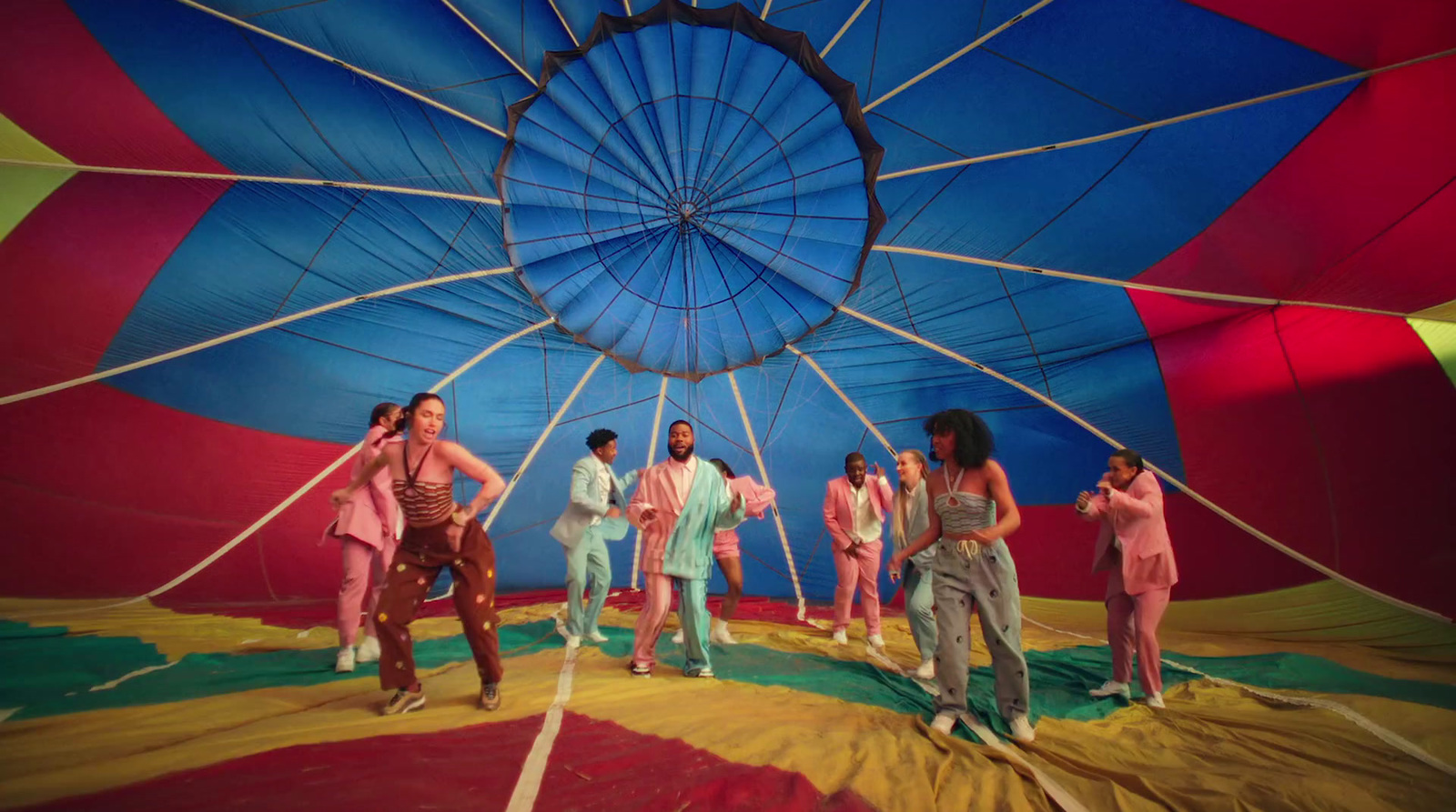 a group of people standing inside of a colorful hot air balloon