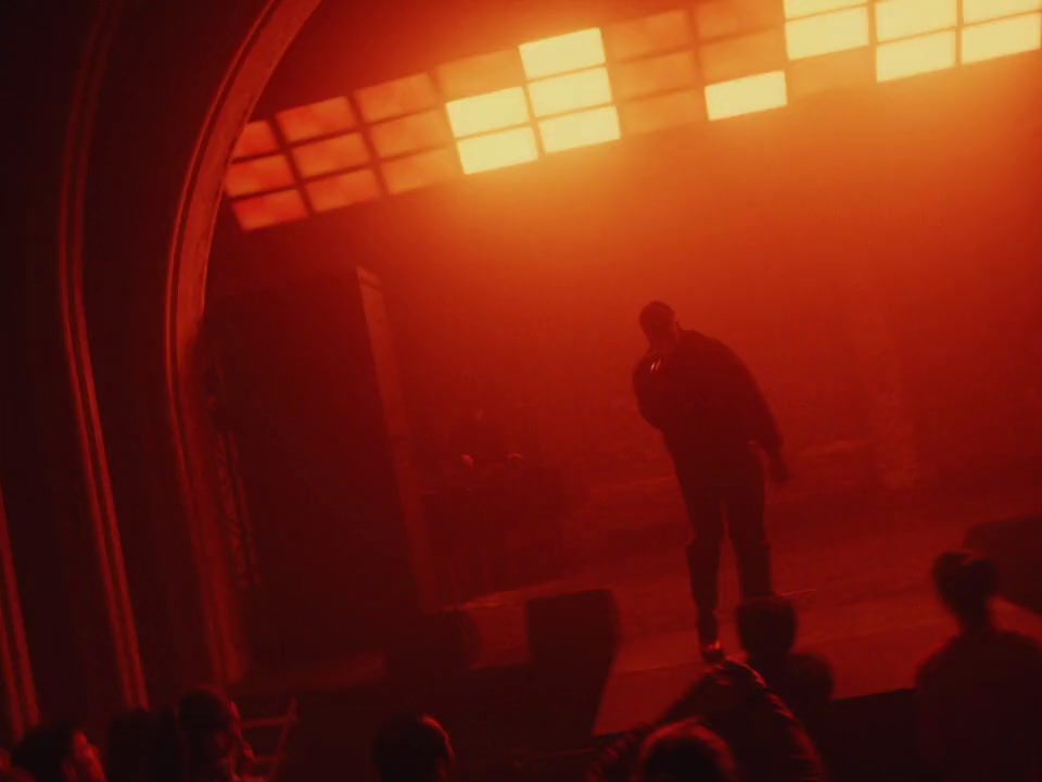 a man standing on top of a stage in front of a crowd