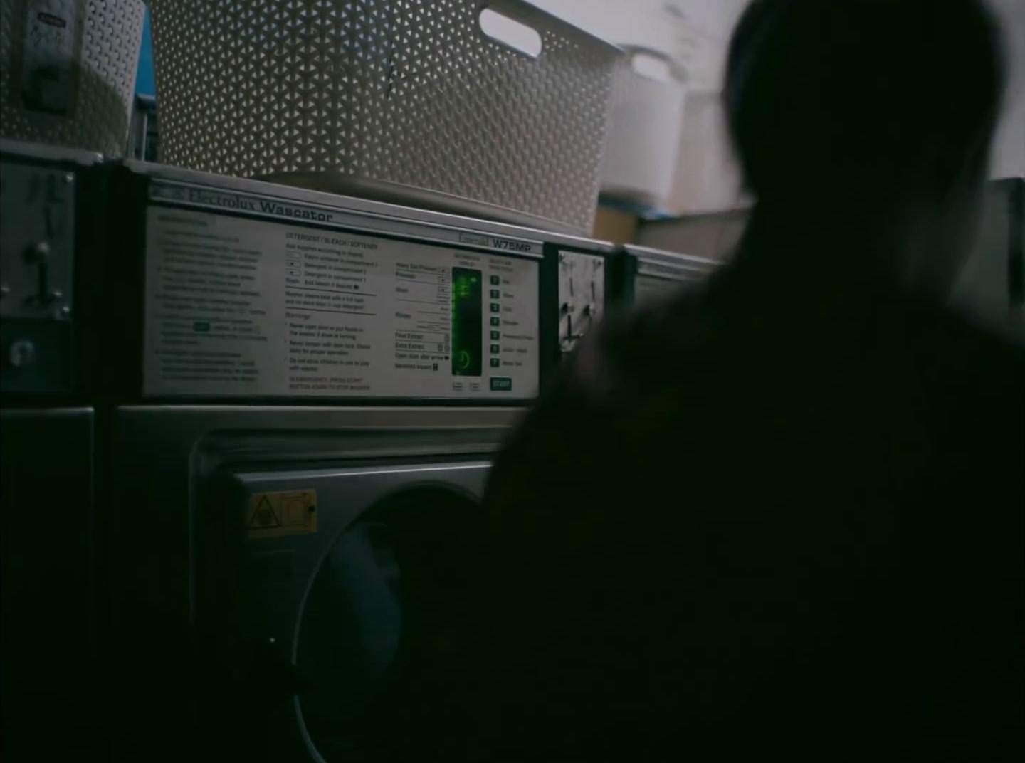 a person sitting in front of a stack of microwaves