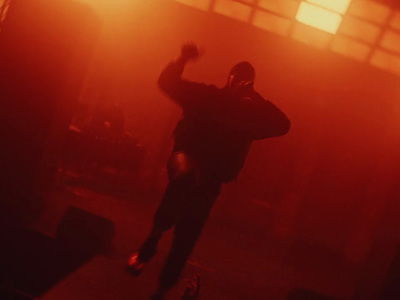 a man in a dark room holding a cell phone to his ear