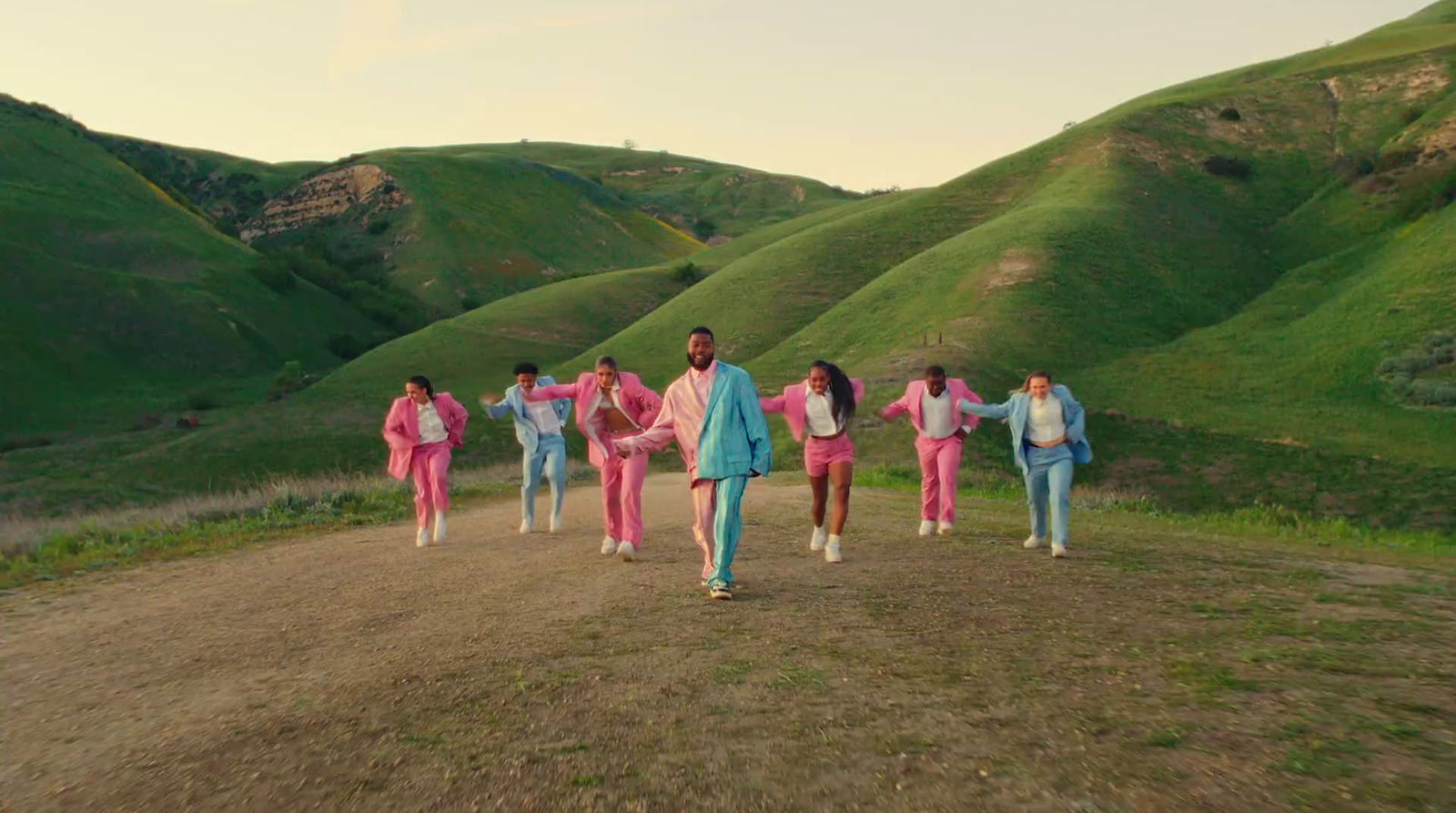 a group of people walking down a dirt road