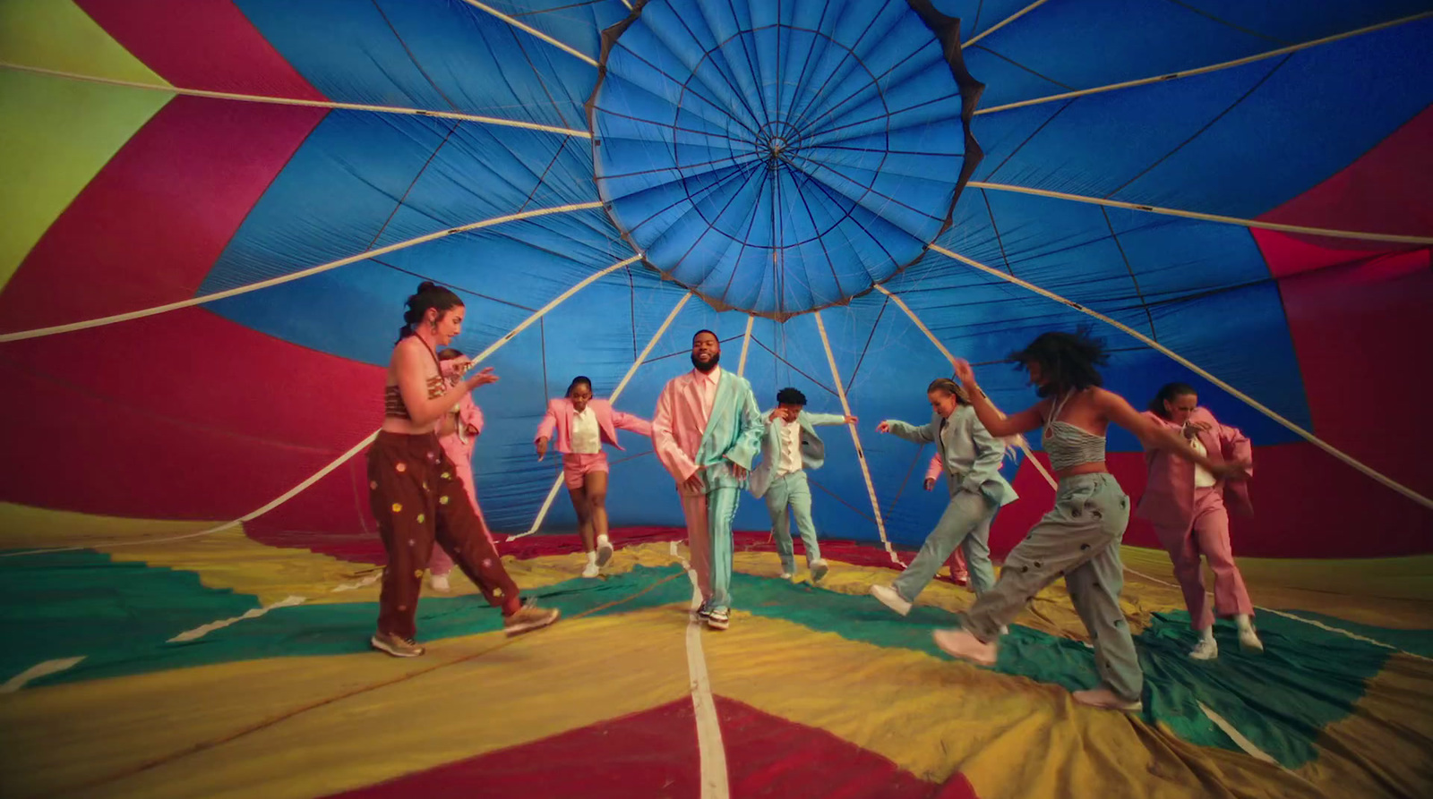 a group of people standing inside of a colorful hot air balloon