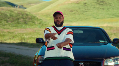 a man standing in front of a car holding a frisbee