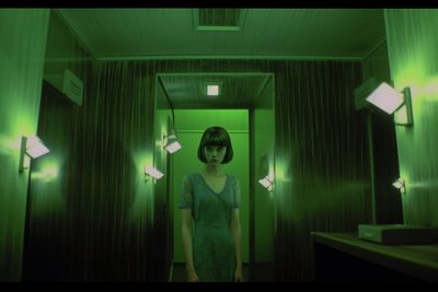 a woman standing in a hallway in a green room