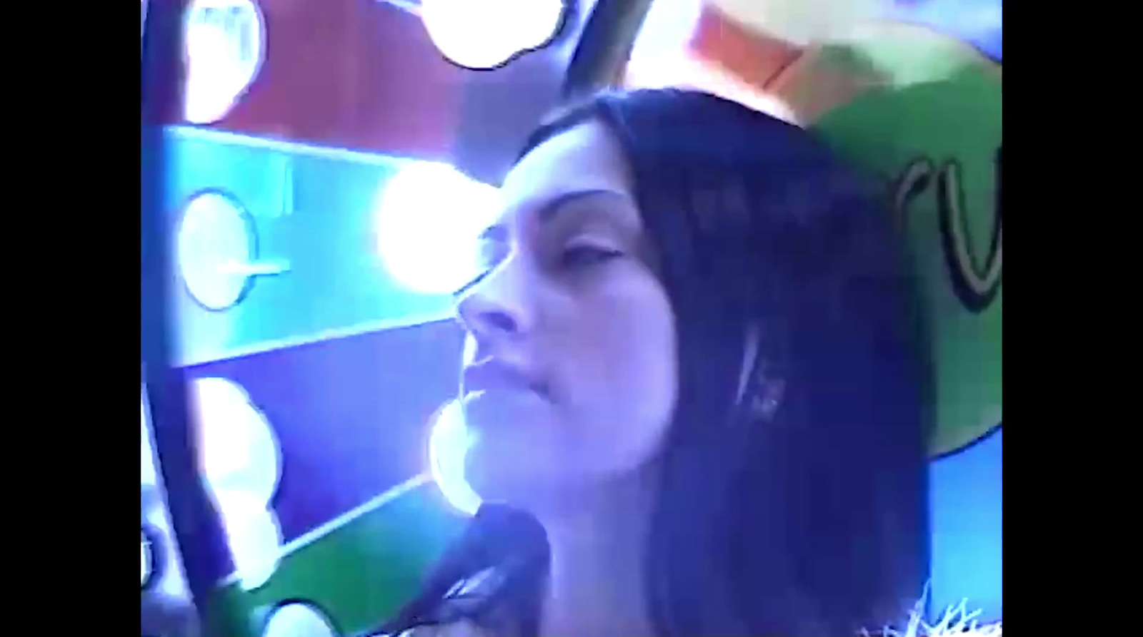 a woman holding a microphone in front of a carnival wheel