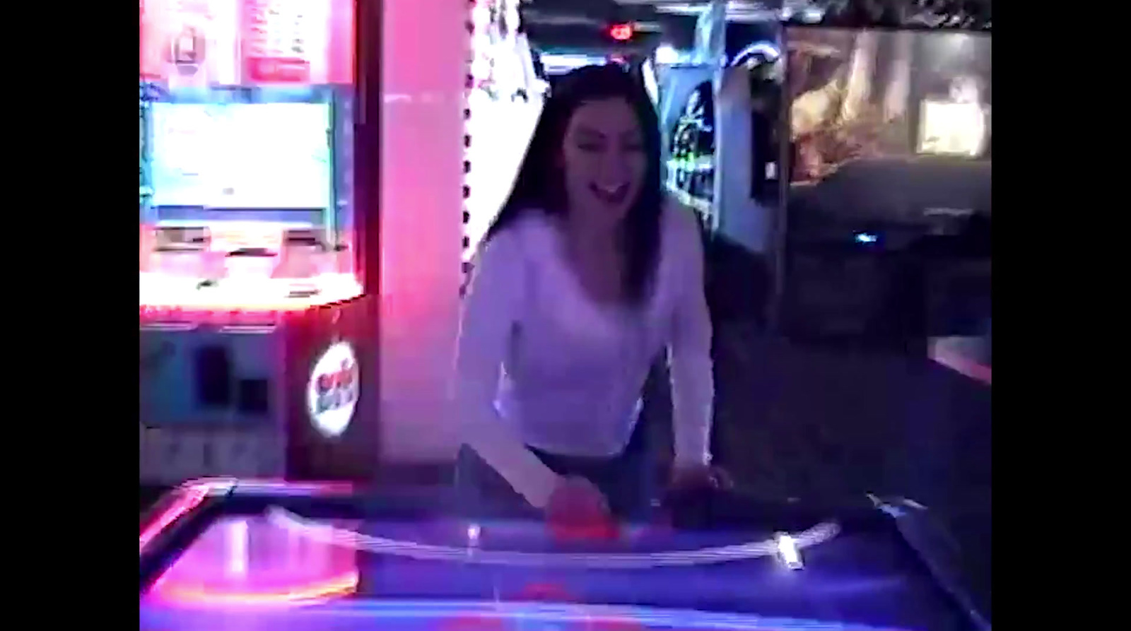 a woman in a white shirt is playing a video game