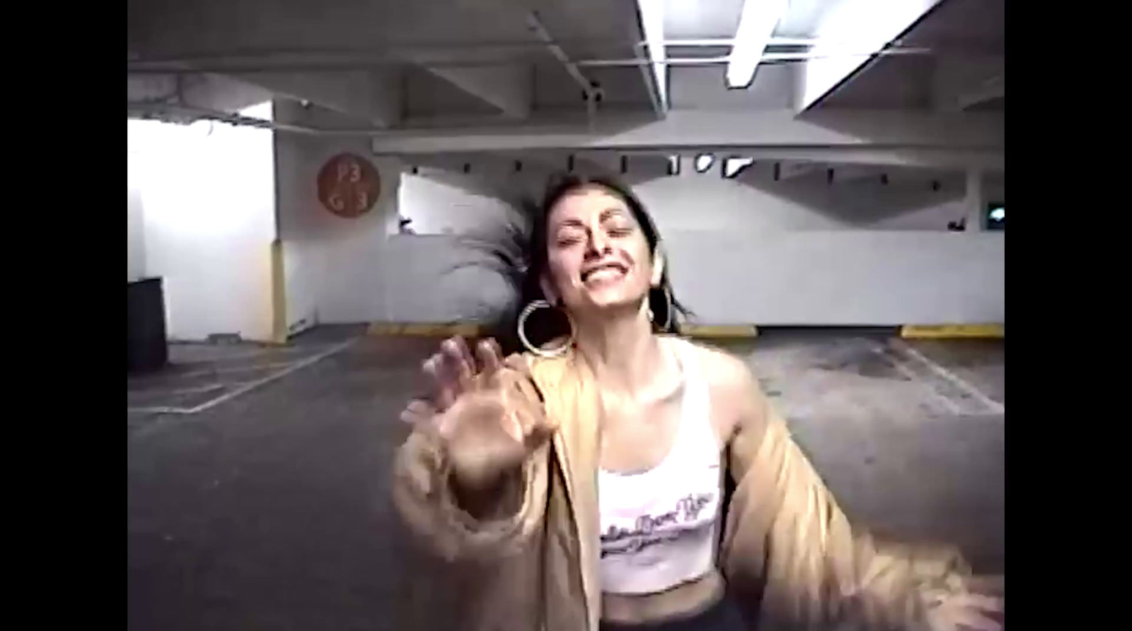 a woman is dancing in a parking garage