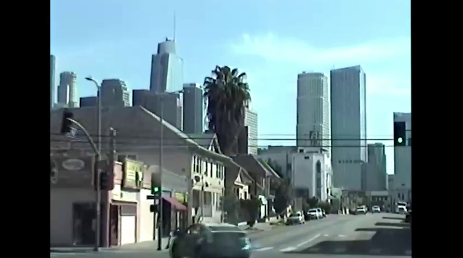 a car driving down a street next to tall buildings