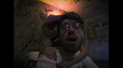 a man holding a woman in his arms in a room with graffiti on the walls