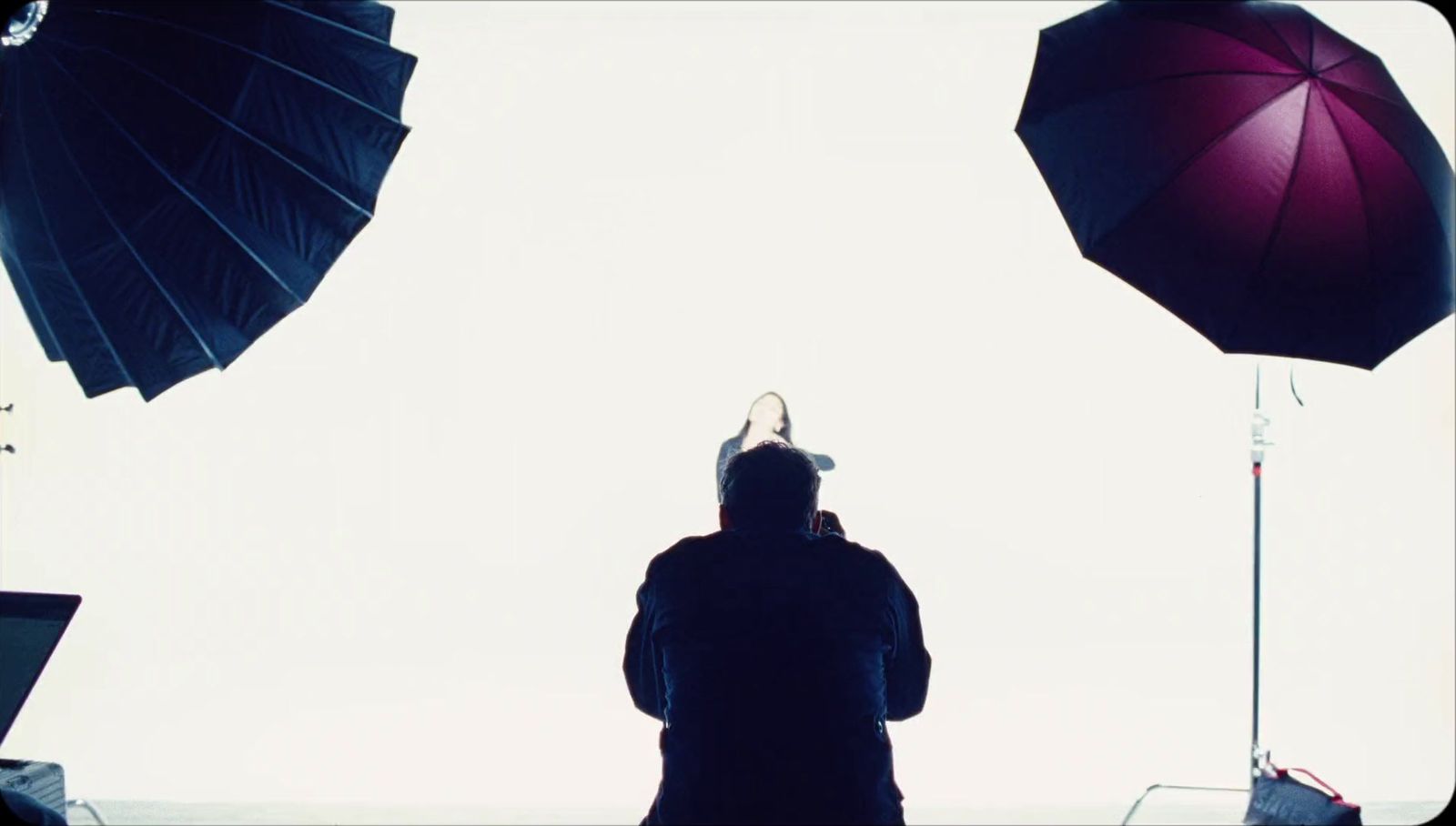 a person standing in front of umbrellas with a sky background