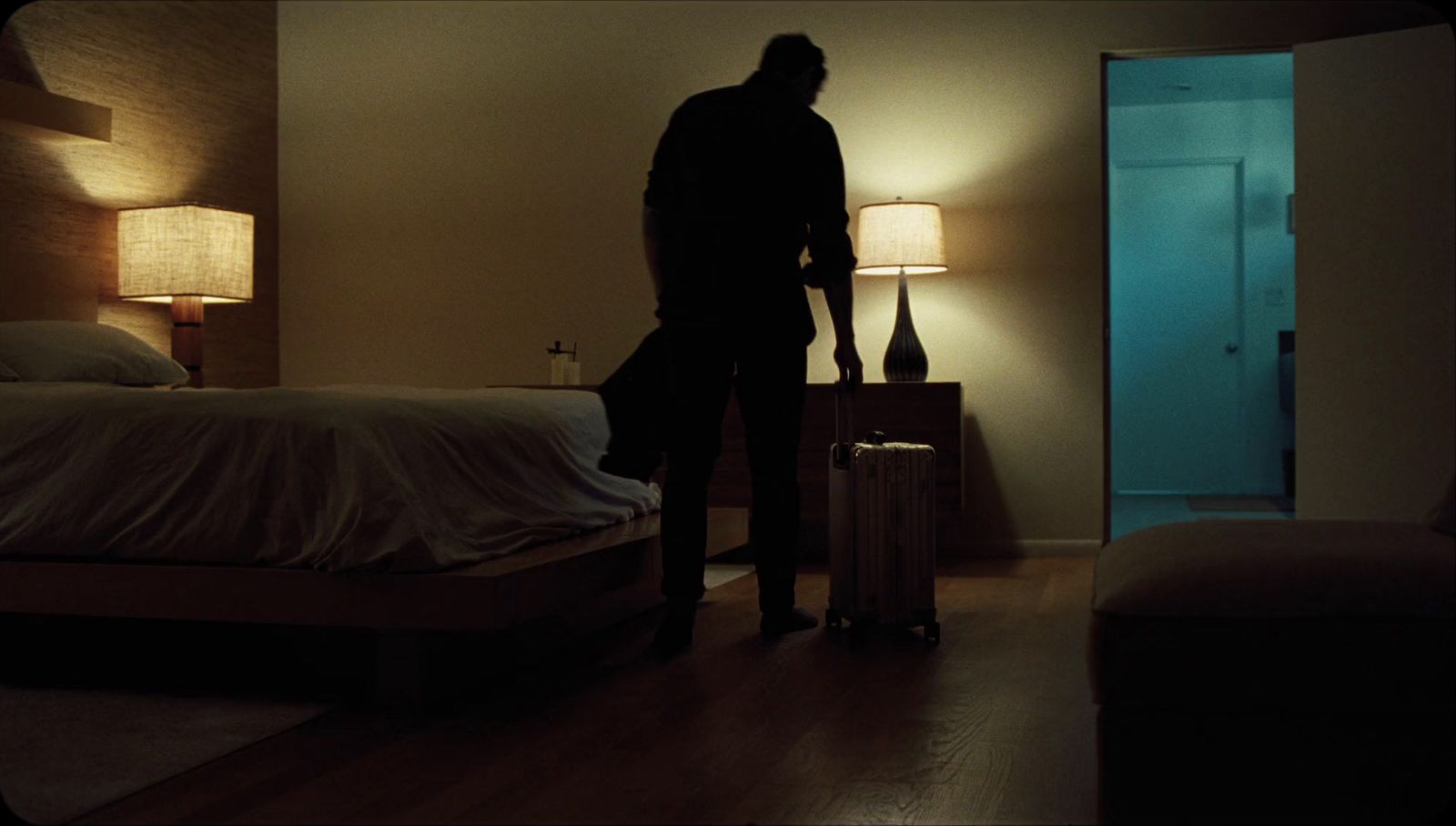 a man standing in a dimly lit bedroom