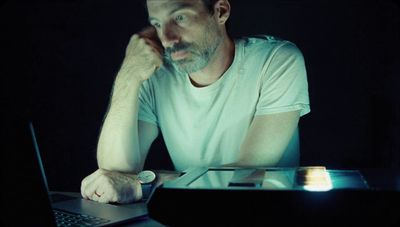 a man sitting in front of a laptop computer