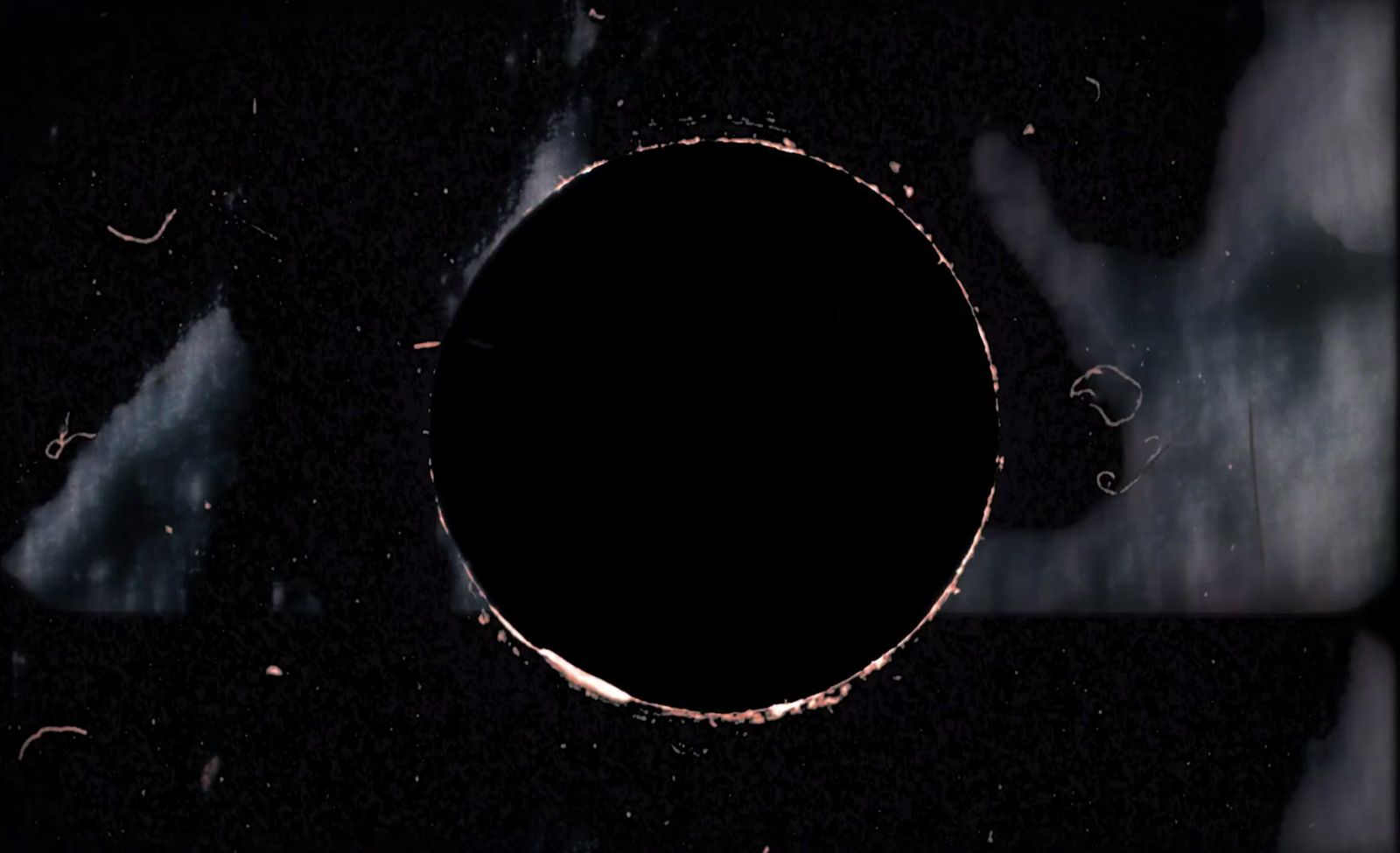 a black hole in the middle of a dark sky