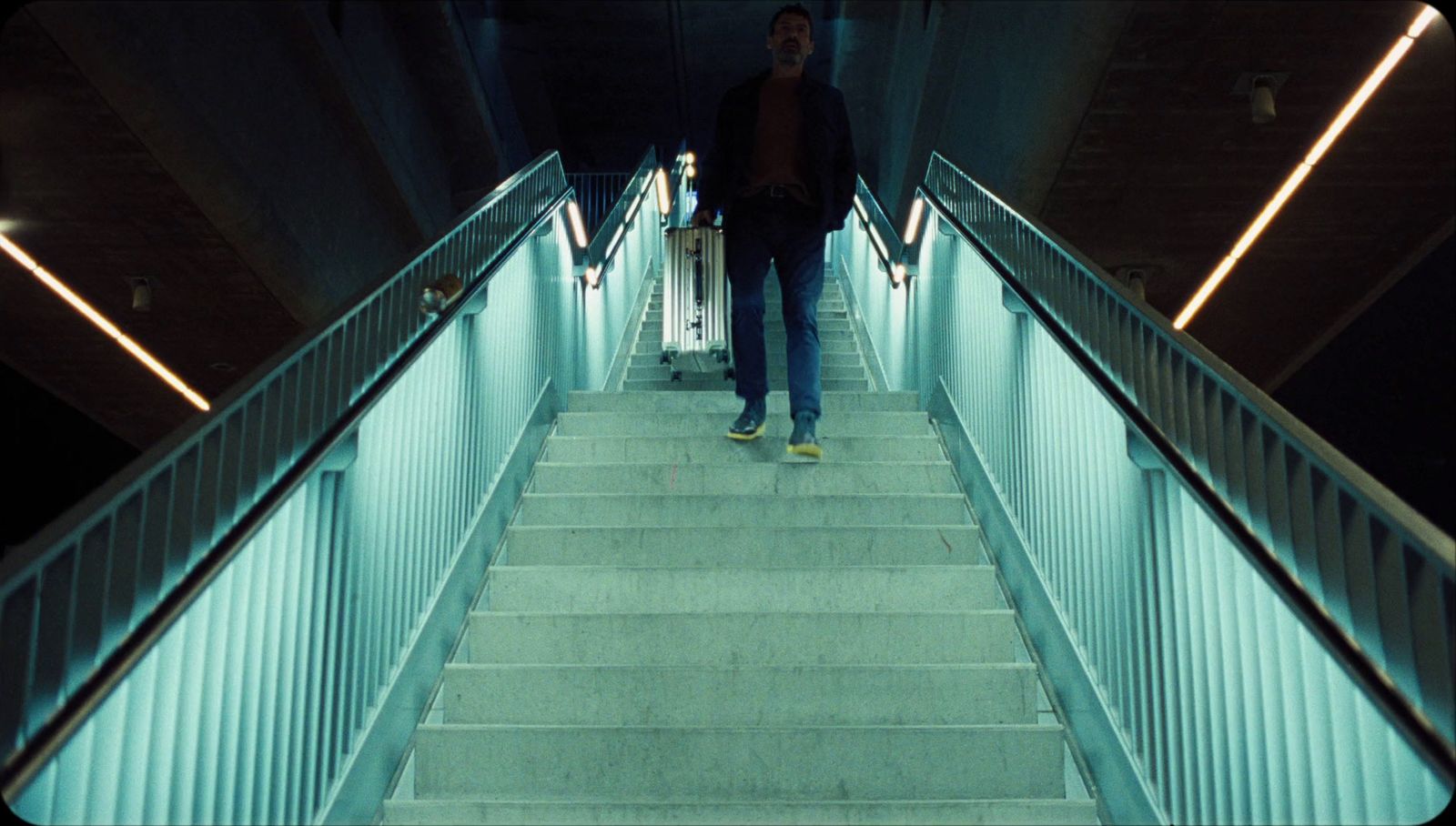 a man walking down a flight of stairs with a suitcase